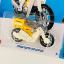 2023 Hot Wheels Dollar General Exclusive Honda Super Cub Custom blanco con amarillo MCCR Primera Edición